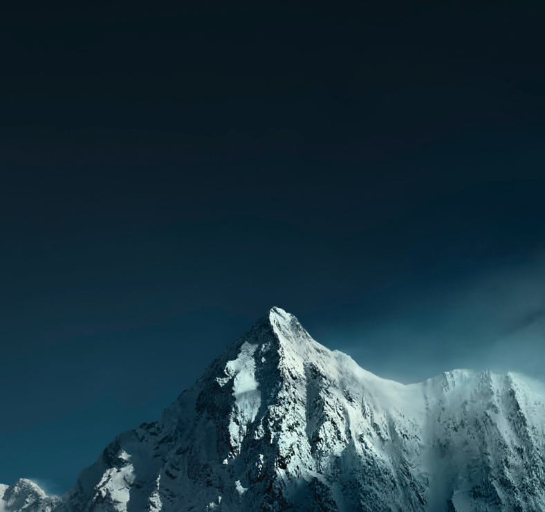 Snow-covered mountain peak under a dark sky